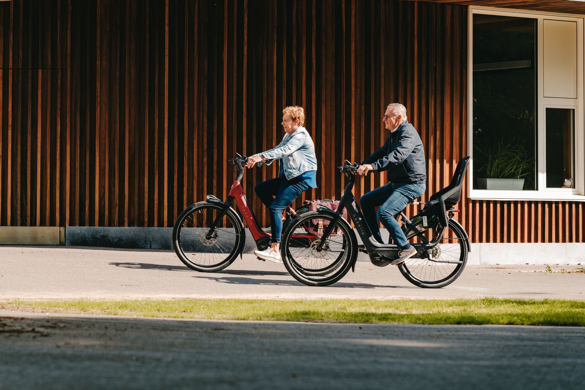 Ouder koppel op elektrische fietsen zijaanzicht